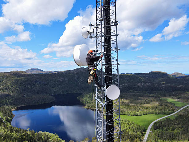 istock Engineer utility infrastructure worker at big steel mast working with radio link, microwave, 4G, 5G 2217619034