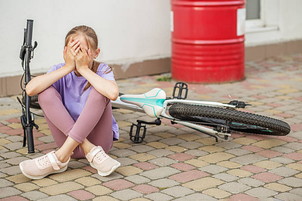 istock Sad girl sitting after bicycle fall 2217619642