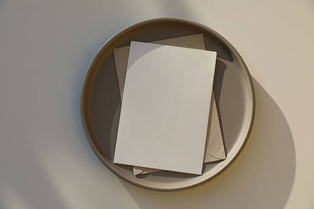 istock Elegant stationery composition. vertical blank greeting card, invitation, mock up scene. Brown ceramic plate. Beige table background in sunlight, shadows, flat lay, top view. Minimal still life. 2217620160