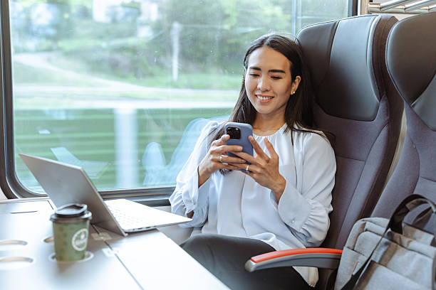 istock Woman using smartphone and laptop while traveling on modern train 2217620710
