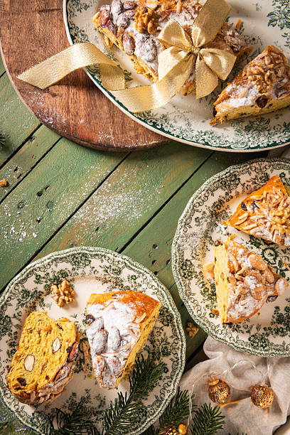 istock Festive Bolo Rainha slice on green plate, with powdered sugar, almonds & walnuts, on a green table with Christmas decor. A traditional Portuguese Christmas, New Year's & Epiphany dessert. 2217621032
