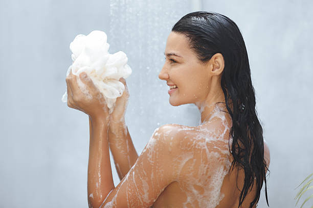 istock Smiling Woman Lathering Loofah in Relaxing Shower Routine 2217624360