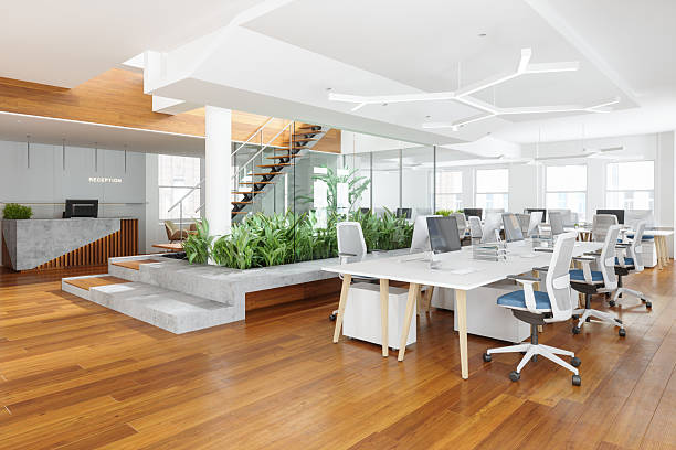 Modern Open Plan Office With Office Chairs, Computers, Reception Desk, Plants And Staircase