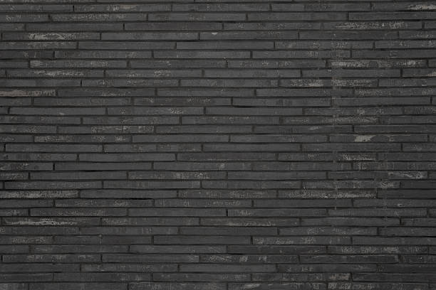 istock Black wall of black bricks - gloomy room. 2217627307
