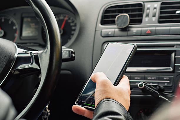 istock Hand holding a smartphone with navigation app open while driving, illustrating everyday reliance on digital maps during car journeys. 2217629427