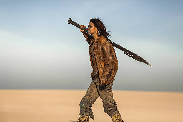 istock Fierce Post-Apocalyptic Woman With Sword Walking Across Desert Alone 2217630179
