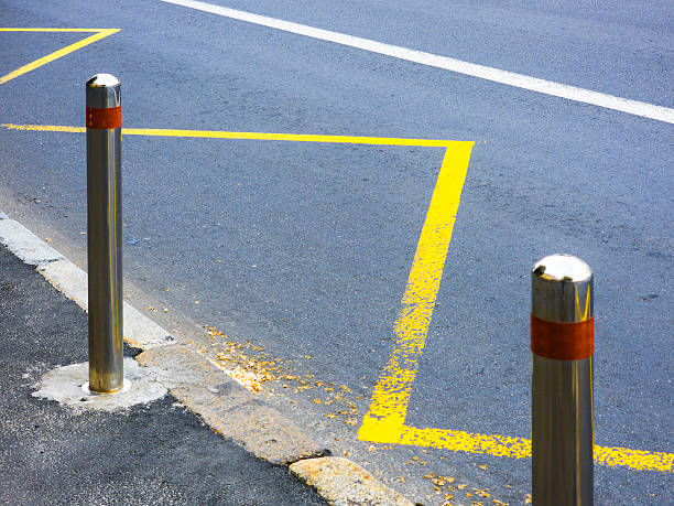 istock Metallic bollards delimiting a reserved parking space with yellow lines 2217630611