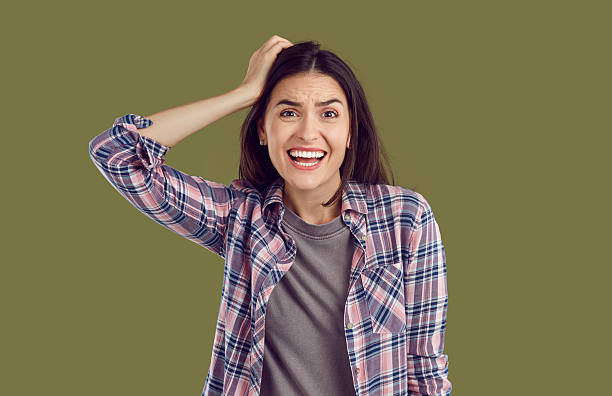 istock Stressed, nervous woman holding hand on head and looking at camera with worried expression 2217631213