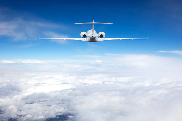 Passenger jet airplane flying above clouds