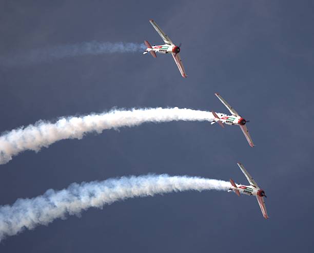 istock T-6 Harvard Performing Acrobatics Leaving a Trail Against Clear Blue Sky at airshow 2217633443