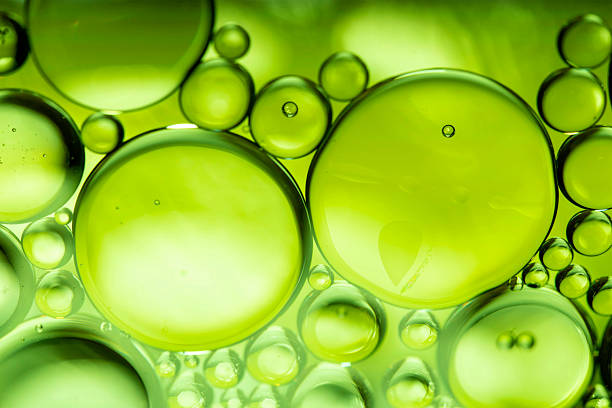 istock lemon drops of oil or serum texture background. Abstract lemon fluid with bubbles 2217634991