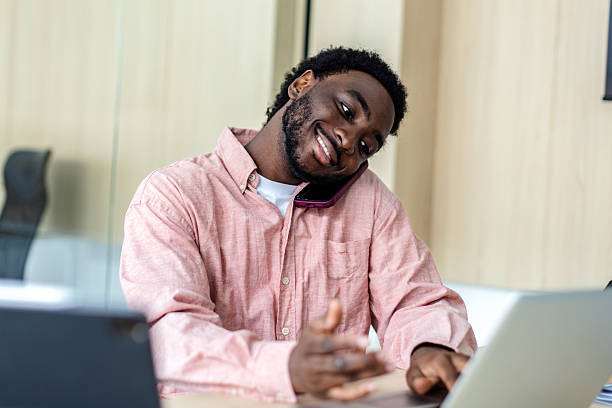 istock Young businessman confidently managing a client call while working on a modern laptop in a professional office environment 2217635444