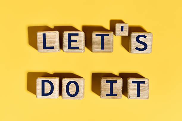 istock Let's do it motivation phrase on wooden blocks over yellow background 2217636937