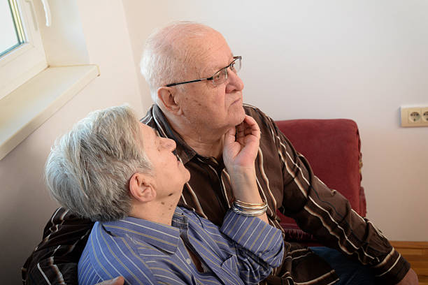 Cute 80 plus year old married couple posing for a portrait in their house. Love forever concept.