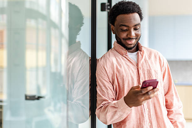 istock Young businessman using smartphone in modern office, showcasing confidence and success in his career 2217637077