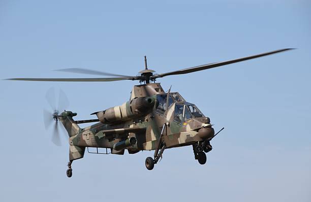 istock Military Denel Rooivalk Helicopter Hovering in Clear Sky Showcasing Camouflage Paint Design at airshow 2217637449