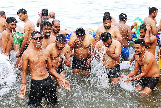 A group of young men immerse themselves in the sacred river Ganges in Prayagraj . Bathing at the Maha Kumbh Mela Festival is considered auspicious and believed it amplifies divine energy while purifying body and soul.