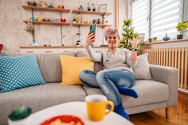 istock Young Woman Having A Video Call Using Phone On The Sofa At Home 2217639766