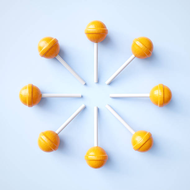 istock Orange lollipop candies on blue background 2217639906