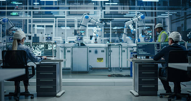 istock Establishing Shot at an Electronics Factory with Robotic Arms. Diverse Engineers and Developers Working on Desktop Computers 2217640954