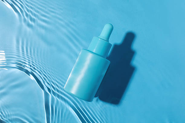 istock Blue serum bottle on water surface. Face serum mockup. Beauty concept. 2217641235
