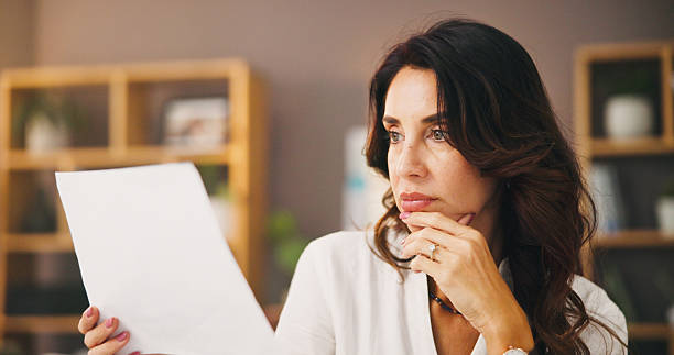 istock Thinking, documents and remote worker with woman in home office for research, planning or reading. Freelancer, paperwork review and copywriting with person in living room for entrepreneur feedback 2217641313
