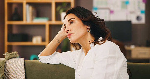 istock Thinking, lonely and woman in home on sofa with anxiety for issue, problem and reflection in living room. Apartment, morning and thoughtful person with worry, overthinking and wondering in house 2217641347