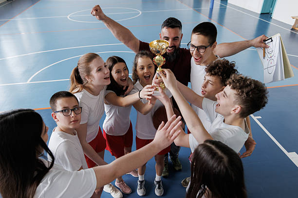 istock Coach celebrates the victory with his team holding the cup 2217641563