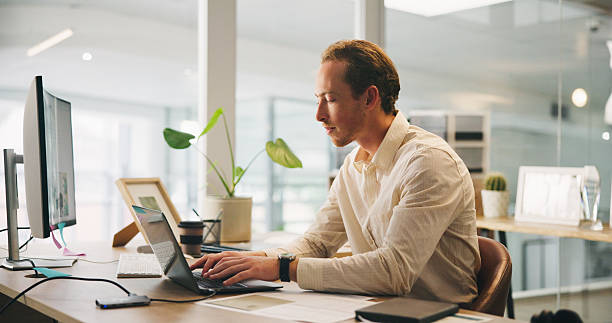 istock Man, typing and research on laptop for business, email draft or connectivity in office. Accountant, thinking and tech in workplace for tax compliance, networking or website for company income filing 2217641863