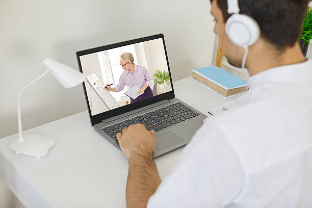 istock Young man sitting at laptop computer, having online class or watching video lecture 2217641991