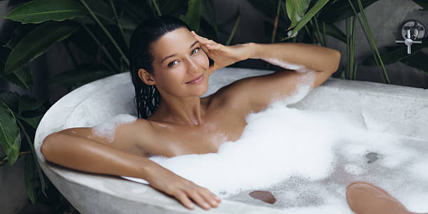 istock Smiling Woman Relaxing In Bubble Bath Amidst Tropical Greenery 2217642029