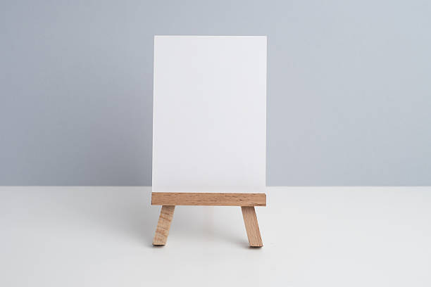 istock Easel and concrete flowerpot with a flower on a colored background. 2217648957