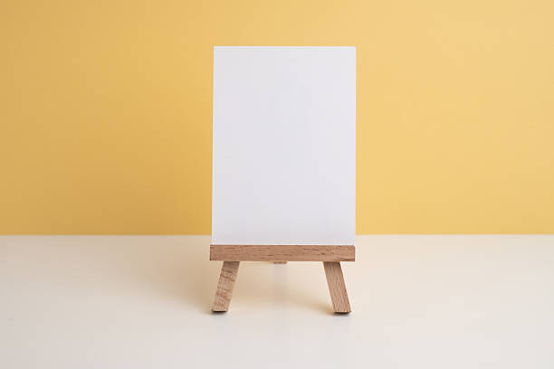 istock Easel and concrete flowerpot with a flower on a colored background. 2217649026