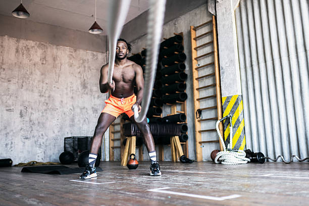 istock Man exercising with battle ropes in an industrial gym setting 2217651874