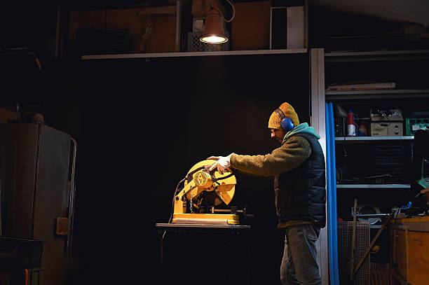 istock Craftsman working with chop saw in workshop at night 2217654398