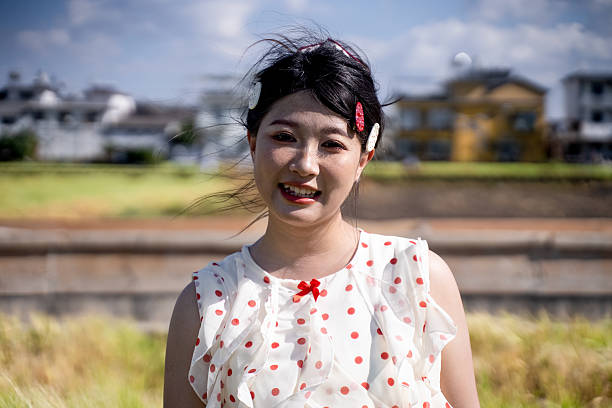 The girl smiling at the camera is outdoors.