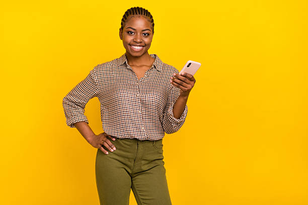 istock Photo of confident pretty lady dressed checkered shirt typing modern device empty space isolated yellow color background 2217658044