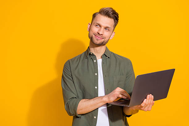 istock Portrait of attractive minded smart clever cheerful guy using laptop thinking copy space isolated over bright yellow color background 2217658961
