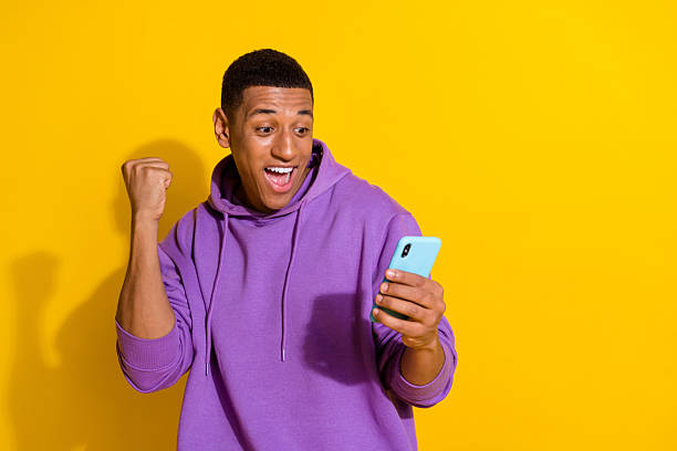 istock Portrait of attractive cheerful guy using device having fun copy space 5g isolated over vivid yellow color background 2217660890