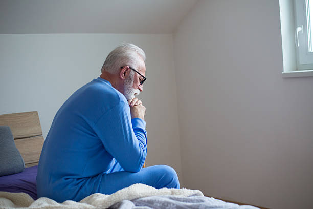 istock Sad senior man sitting on the bed in the morning 2217665319
