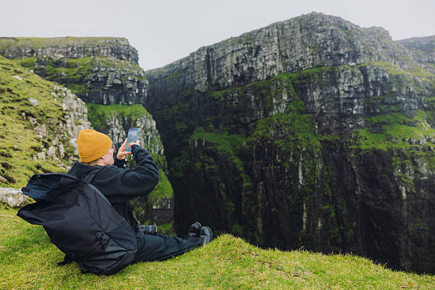 istock Traveller With Backpack Photographing Dramatic Scandinavian Mountain Landscape by Smartphone 2217669025