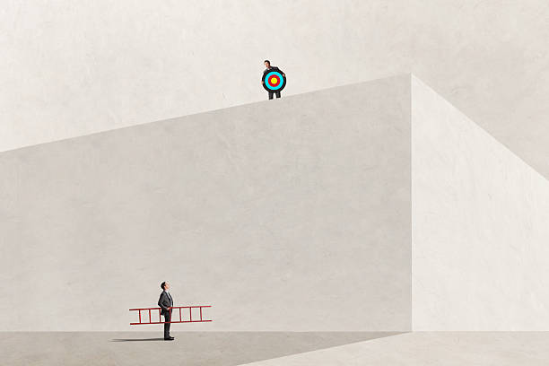 A man holding a ladder contemplates how he is going to rise to the next level as he looks up at another man holding a target and looking down at him.