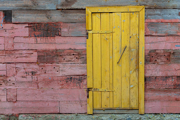 Red wooden wall and yellow barn door.