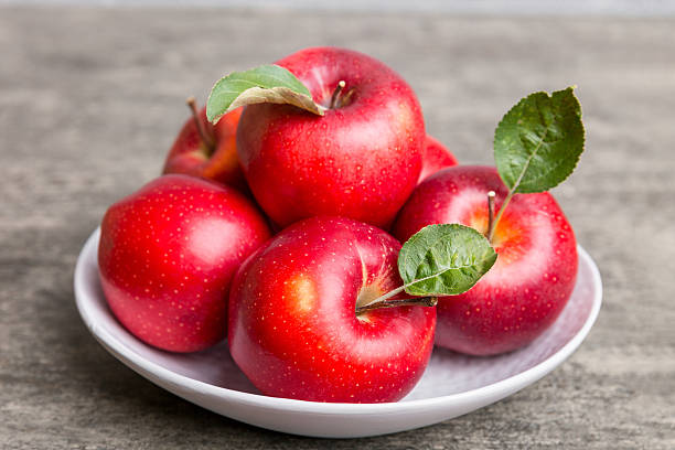 istock juicy red apples in a bowl or plate on the table top view. Copy space 2217673431
