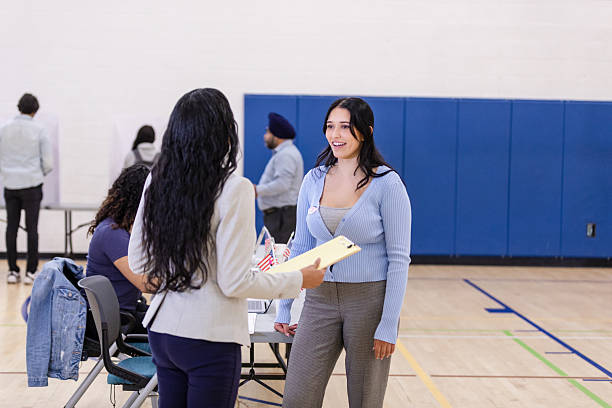 istock Two Women Talking at Polling Place, Election Day 2217675214