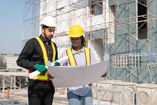 istock Civil engineer and architect with blueprint discussing inspecting structure building project at construction site. 2217677506