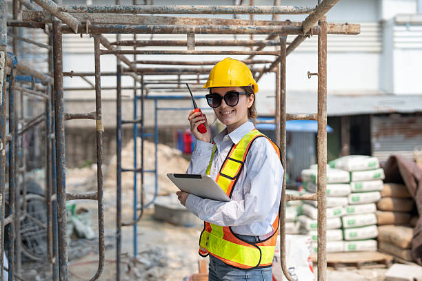 istock Civil female engineer holding tablet and using radio talking working at construction site. Female inspector inspecting building progress on building site. 2217678113