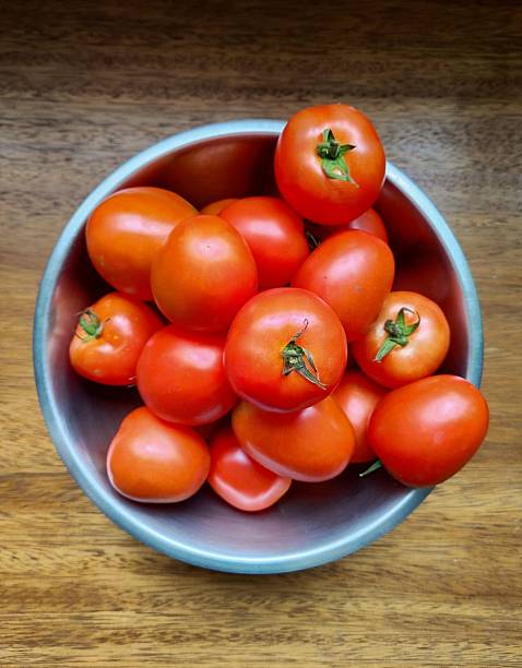 istock Fresh Tomatoes in a Bowl – Top View on Wooden Background 2217680549