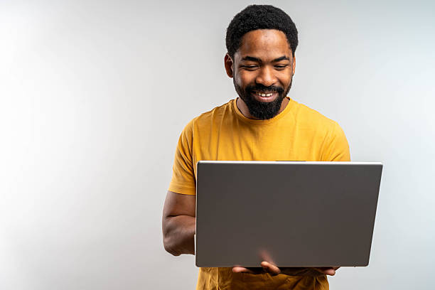istock Young man standing holding laptop with happy smile 2217682324