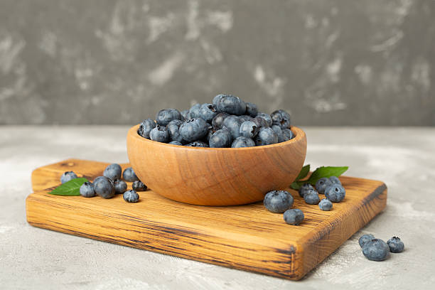 istock Bowl with fresh blueberries on concrete background 2217685939